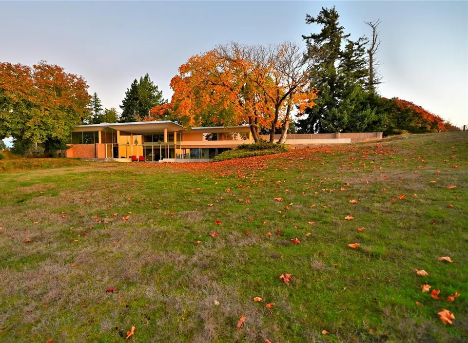 Autumn view of the Filberg House across meadow and changing foliage.
