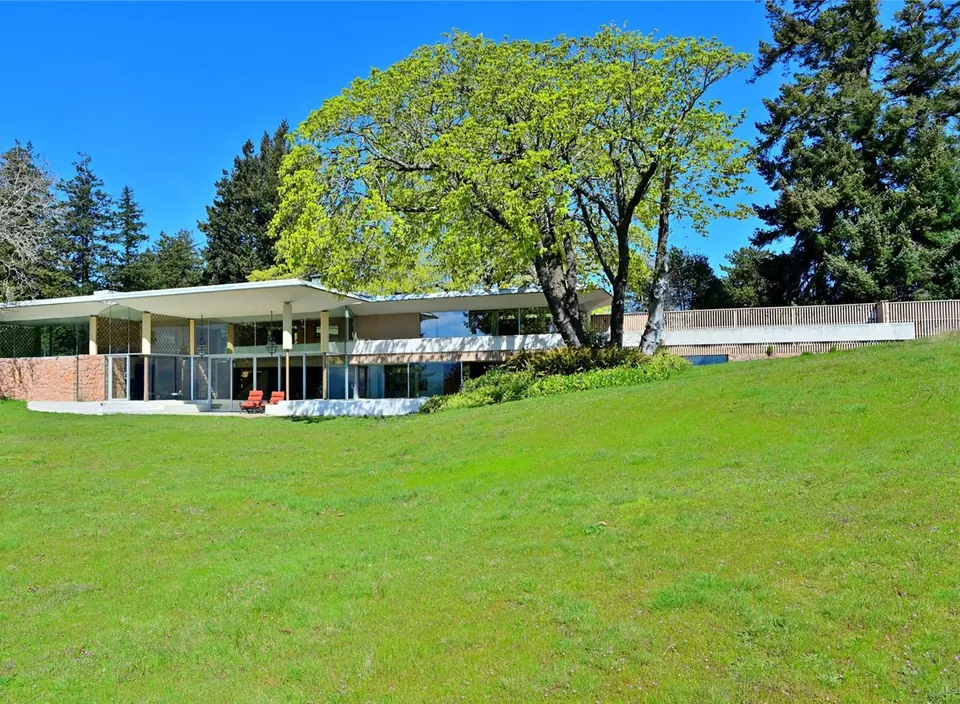 Spring view of the Filberg House beside a mature oak and open lawn.