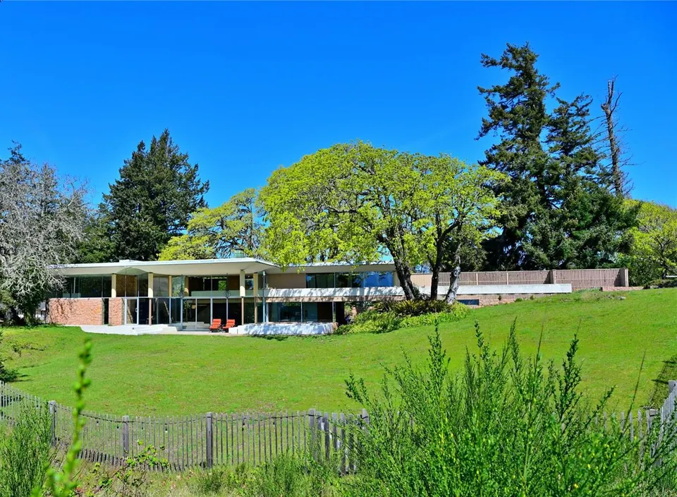The Filberg House across a green lawn beneath mature trees in Comox.