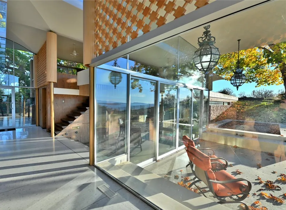 Interior glass walls and stair beside the Filberg House reflecting pool.