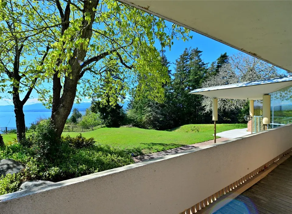 A path and mature trees near the glass-walled Filberg House.