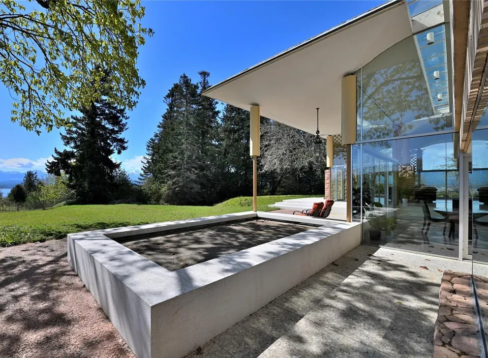 Stone terrace and glazed exterior of the Filberg House overlooking the grounds.
